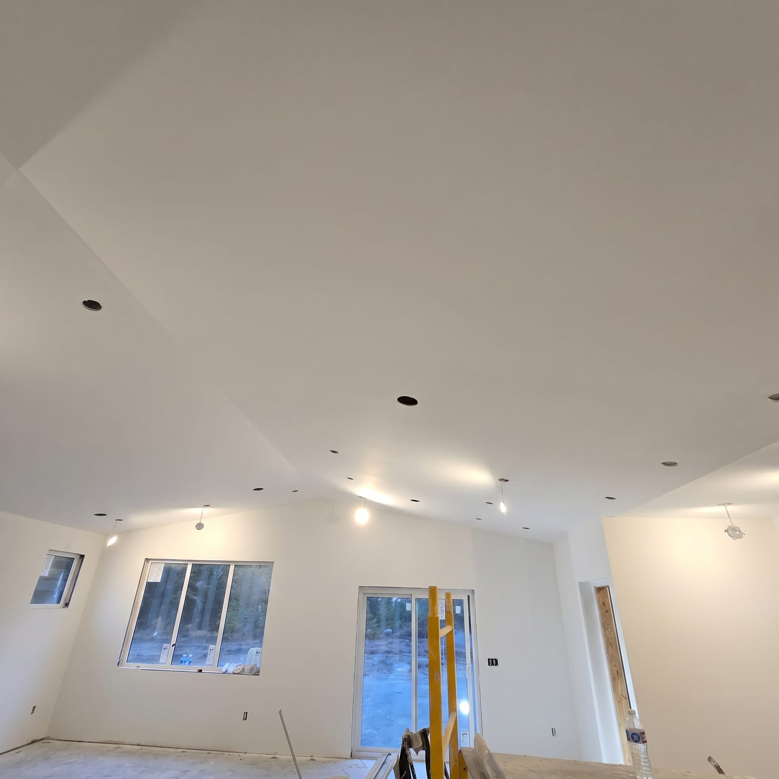 Vaulted ceiling with clean finished drywall and recessed lighting.