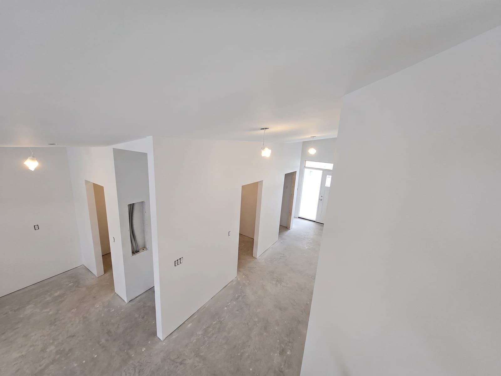 Finished hallway with three doorways cut cleanly into the drywall.