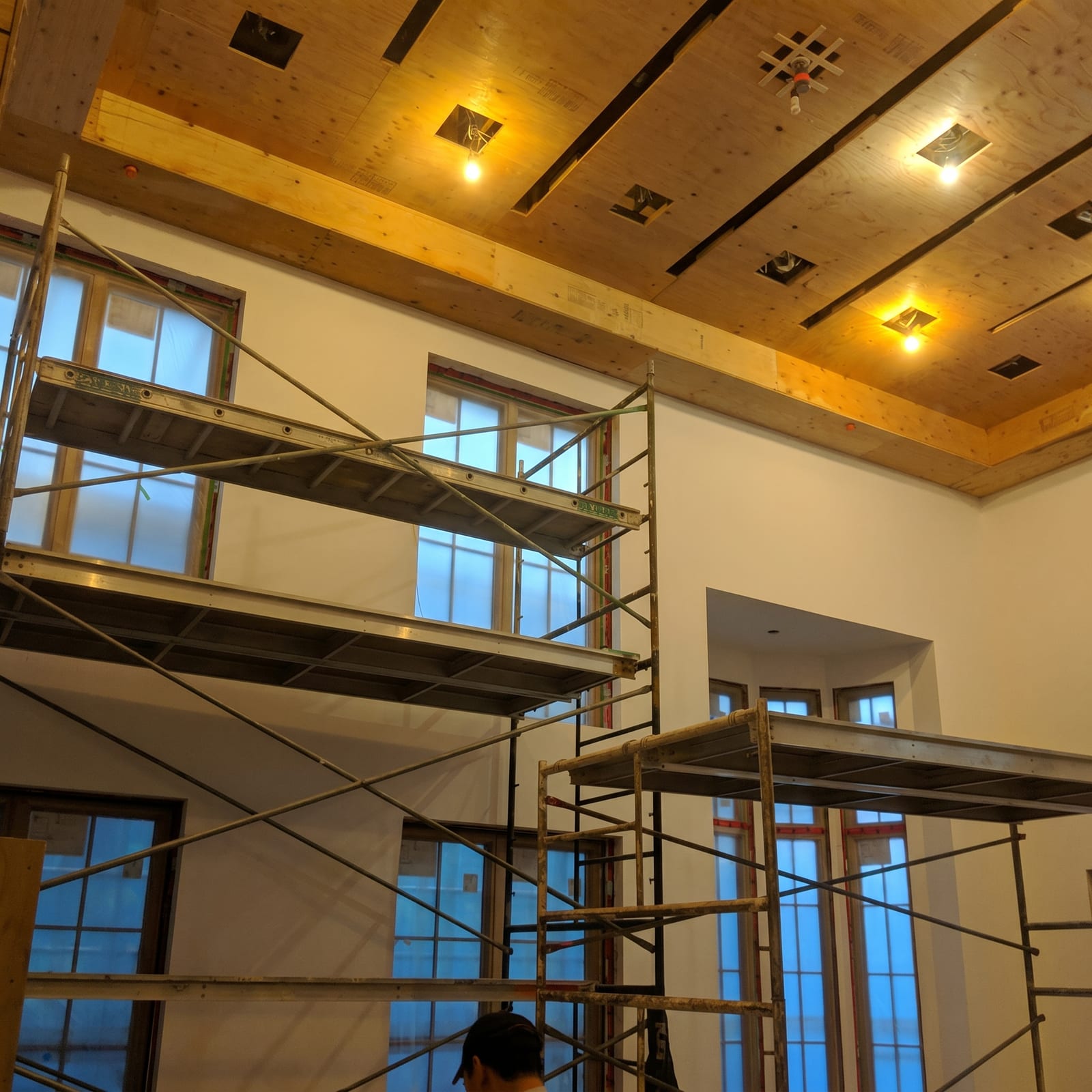 Scaffolding in place inside a double-height room with exposed timber ceiling.