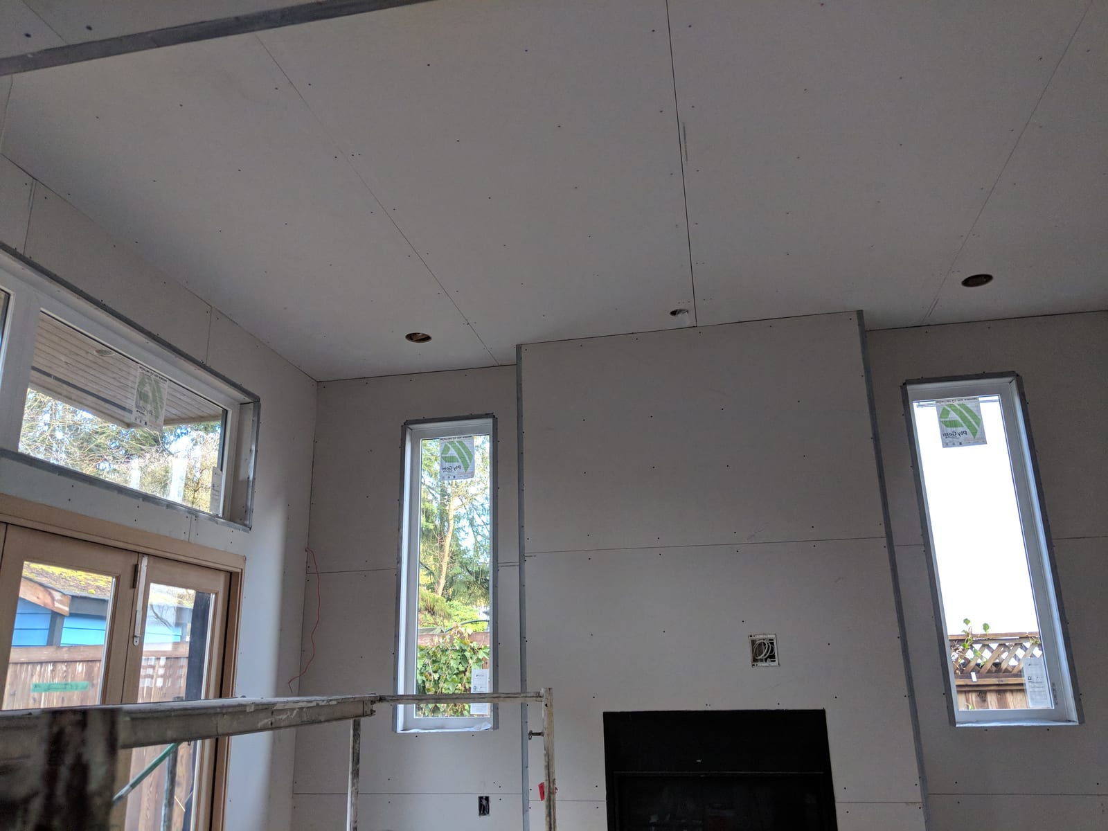 Ceiling being taped — seams and corner bead visible before the mud goes on.