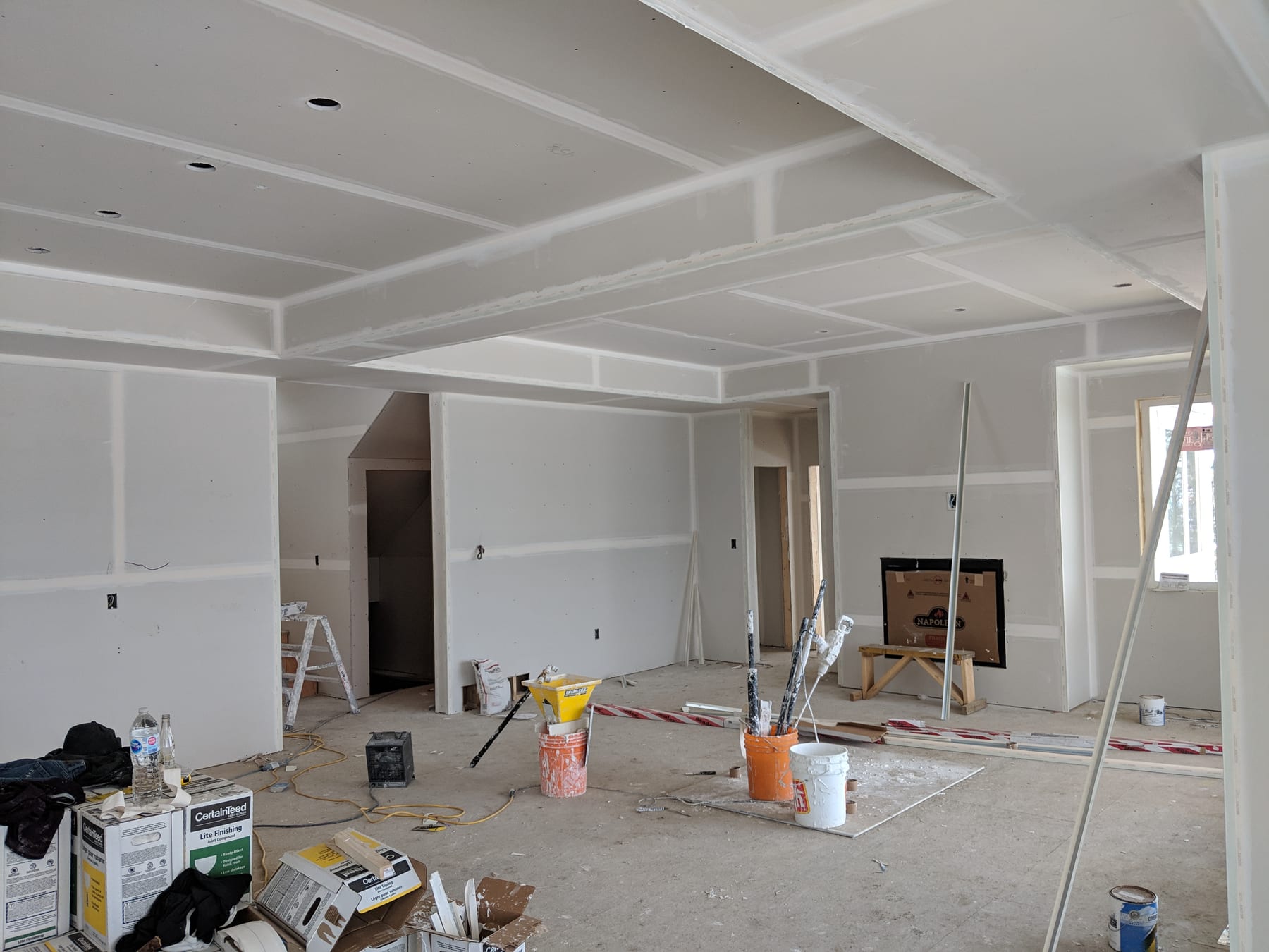 Mid-taping: mud lines visible on the ceiling, tools on the floor.