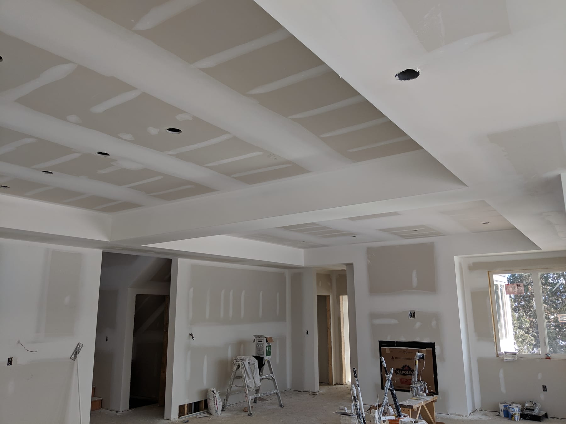 Mud coats drying on ceiling and walls, ladder in place.