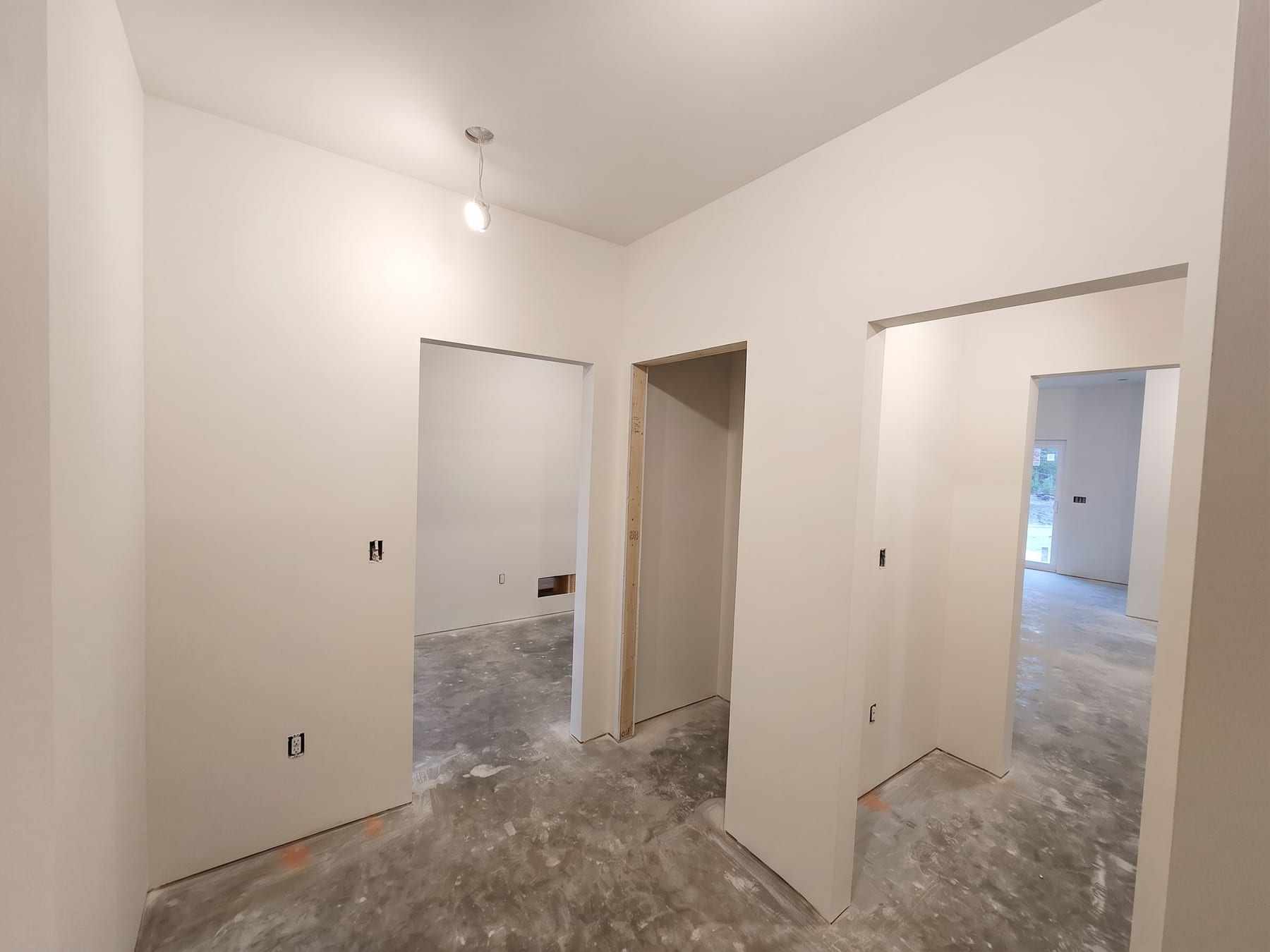 Finished hallway with three doorways opening onto bright rooms.